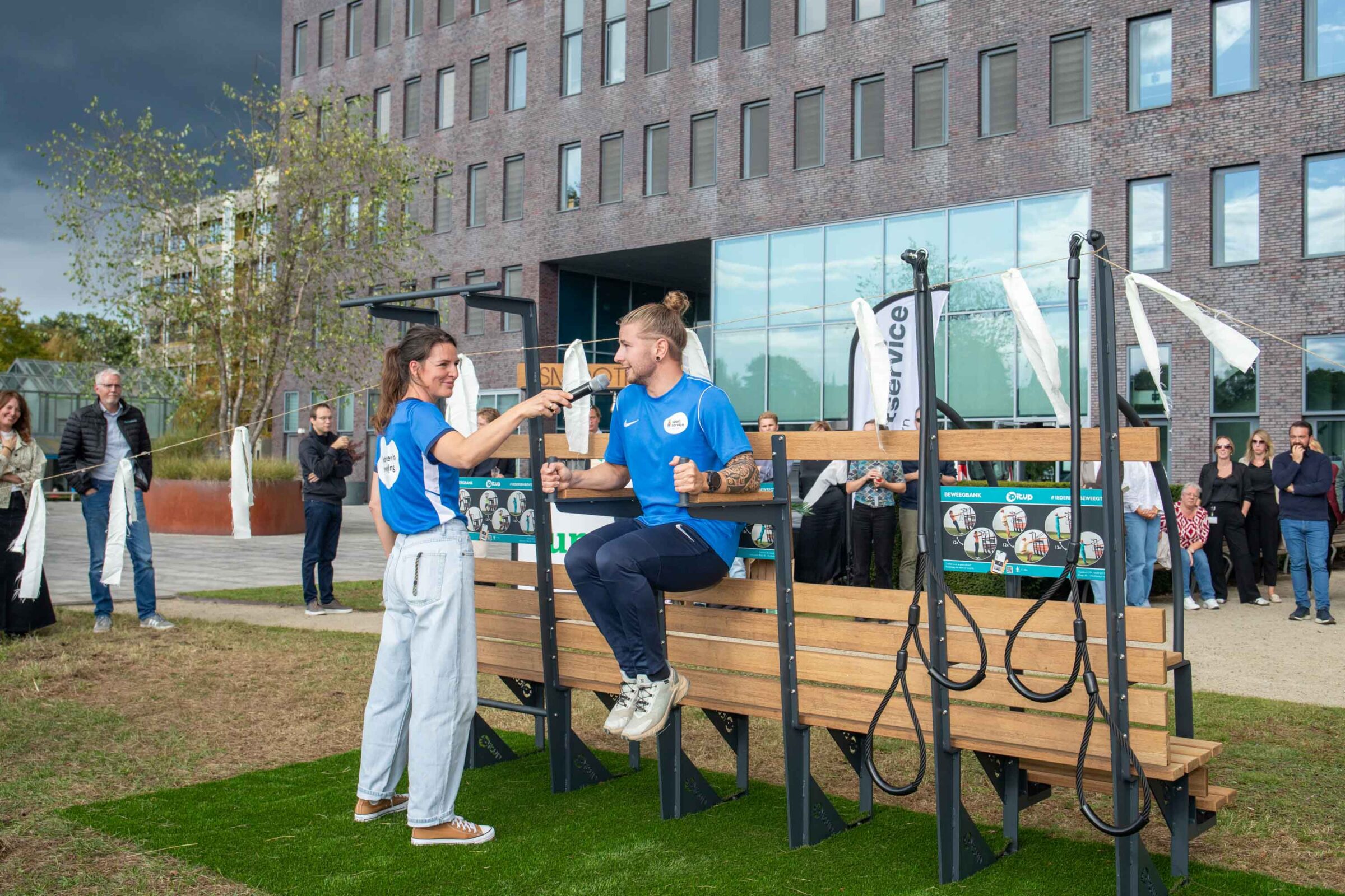 Beweegmakelaar Joanne Bels helpt collega Jelle van Dillen van Sportservice Apeldoorn tijdens een demonstratie van de Beweegbank.